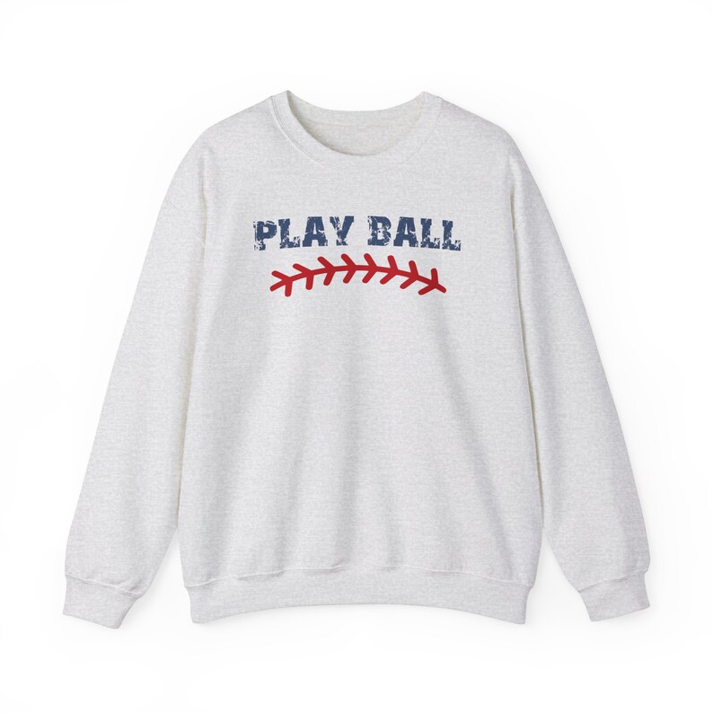 May include: A gray sweatshirt with the text "PLAY BALL" in blue and red stitching on the front.