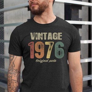 May include: A dark grey t-shirt with a vintage-style graphic that says "Vintage 1976 Original Parts".