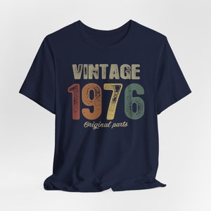 May include: Navy blue t-shirt with a vintage-style graphic that says "Vintage 1976 Original parts".