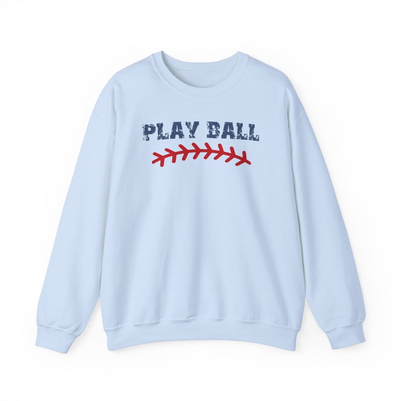 May include: Light blue sweatshirt with the text "PLAY BALL" in navy blue with a red baseball stitch graphic.