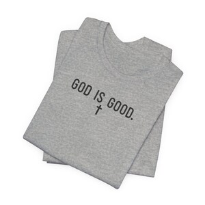 May include: A gray t-shirt with the text "GOD IS GOOD." and a cross symbol.