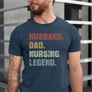 May include: A navy blue t-shirt with the text "Husband. Dad. Nursing Legend." in a vintage style font.