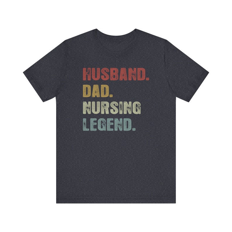 May include: Dark heather grey t-shirt with a vintage-style graphic that reads "Husband. Dad. Nursing Legend."