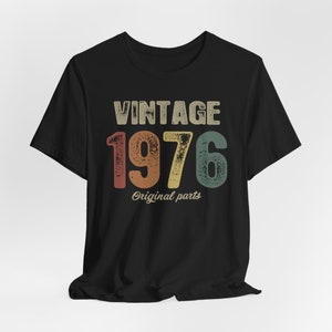 May include: Black t-shirt with a vintage-style graphic that says "Vintage 1976 Original Parts".