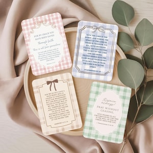 Puede incluir: Cuatro tarjetas decorativas con citas inspiradoras. Las tarjetas tienen un patrón de cuadros en rosa, azul y verde. Cada tarjeta tiene un lazo o cinta decorativa en la parte superior. Las tarjetas están dispuestas en una bandeja de madera.