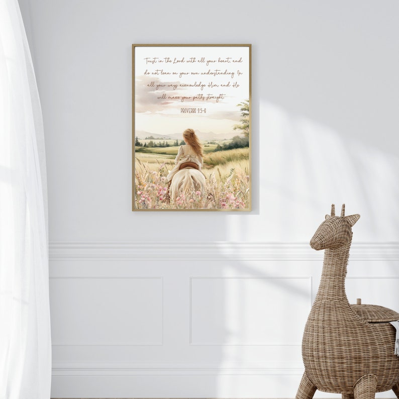 May include: A framed watercolor print featuring a woman riding a white horse through a field of wildflowers. The artwork has a soft, pastel color palette with text at the top that reads "Trust in the Lord with all your hearts and..."