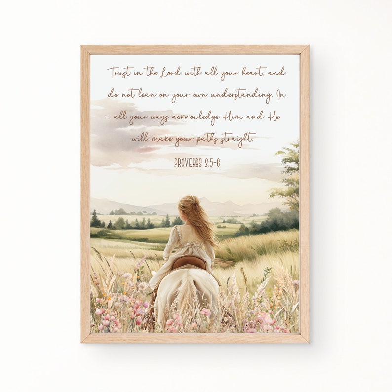 May include: A framed print featuring a watercolor illustration of a girl riding a white horse through a field of wildflowers. The artwork includes the text "Trust in the Lord with all your heart... Proverbs 3:5-6" in a script font. The frame is a light wood color.