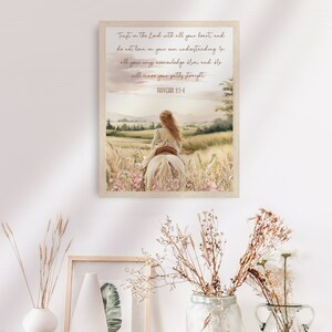 May include: A framed watercolor print featuring a girl riding a white horse through a field of wildflowers. The artwork has a soft, pastel color palette and includes the text "Trust in the Lord with all your heart... Proverbs 3:5-6."