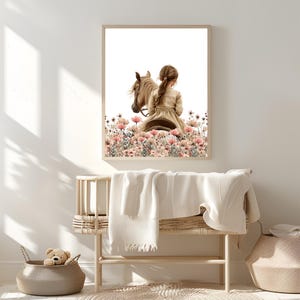 May include: A framed print of a girl riding a horse through a field of pink flowers. The girl is wearing a long, white dress and has her back to the viewer. The horse is brown and has a white mane and tail.