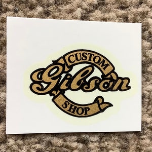Aangepaste gouden sticker voor de kop van de gitaar.