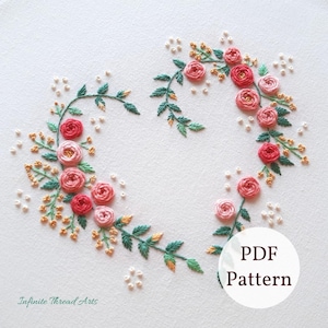 May include: A PDF pattern for embroidery featuring a heart-shaped wreath of pink and red roses with green leaves and white pearl-like beads.