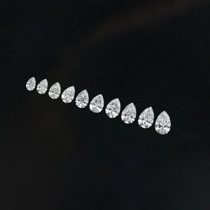 May include: A row of pear-shaped diamonds arranged in a graduated size order, from smallest to largest, on a black background.