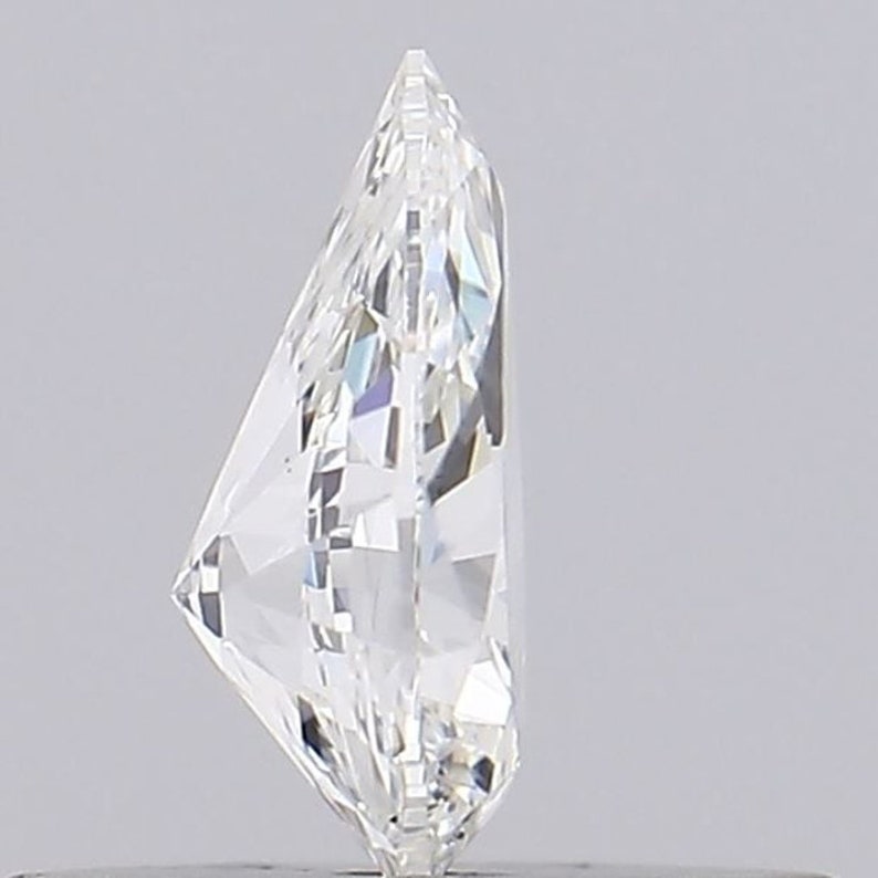 May include: A clear, faceted diamond with a brilliant cut. The diamond is set in a ring setting, with a metal band visible at the bottom of the image.