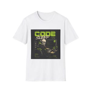 May include: A white short-sleeved t-shirt featuring a graphic print of a skeleton wearing headphones and a hoodie while typing at a computer. The text reads CODE SLEEP, with additional small text elements and green accents on a black square background.