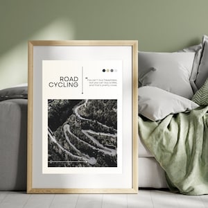 Puede incluir: Una impresi&oacute;n enmarcada con una foto en blanco y negro de un camino sinuoso a trav&eacute;s de un bosque. El texto "ROAD CYCLING" est&aacute; en letras blancas sobre fondo negro. La cita "You can't buy happiness, but you can buy a bike, and that's pretty close." est&aacute; en texto negro sobre fondo blanco.