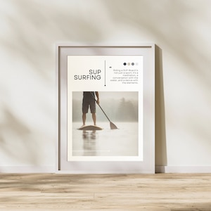 Könnte beinhalten: Gerahmter Druck mit dem Text „SUP SURFING“ und einem Bild einer Person beim Stand-Up-Paddling. Der Druck enthält das Zitat: „SUP-Boardfahren ist nicht nur Sport; es ist Meditation, ein Gespräch mit dem Wasser und ein Tanz mit den Elementen.“