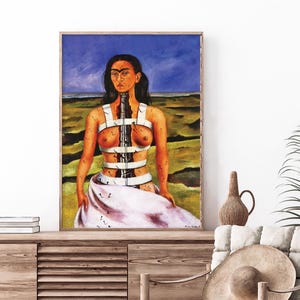 Puede incluir: Una pintura de una mujer con cabello oscuro y una expresión seria. Lleva un corsé blanco con una gran columna vertebral de madera oscura que lo atraviesa. El fondo es un paisaje con colinas verdes y un cielo azul.