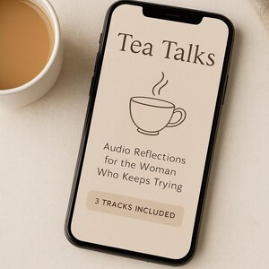 Op de afbeelding: Een smartphone toont "Tea Talks" met een theekopje-afbeelding en de tekst "Audio Reflections for the Woman Who Keeps Trying". Er staat ook "3 TRACKS INCLUDED". Een witte theekop met thee is zichtbaar.