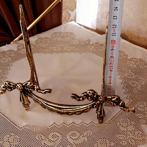 Peut inclure: Un support d&eacute;coratif en m&eacute;tal dor&eacute; avec un motif de n&oelig;ud. Le support mesure environ 38 cm de haut.