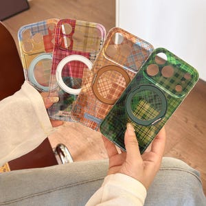 Può includere: Quattro cover trasparenti per smartphone con motivi a quadri colorati in blu, rosso, arancione e verde. Ogni cover include un anello di ricarica magnetico circolare sul retro e un'apertura rettangolare per la fotocamera con fori circolari.