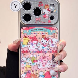 K&ouml;nnte beinhalten: Silberne Handyh&uuml;lle mit einem Karussell-Design mit Zeichentrickfiguren und dem Text "HAPPY EVERY DAY". Die H&uuml;lle hat einen glitzernden oberen Bereich mit Kameraausschnitten.