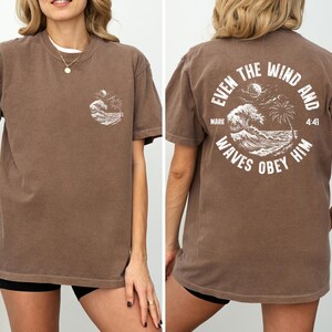 Experience the serene power of faith with our Comfort Colors shirt, inspired by the scripture from Mark 4:41. This waves obey him shirt beautifully captures a moment of divine calm, perfect for those who cherish ocean inspired style and seek a meaningful church service shirt. Crafted for comfort and spiritual connection, it’s an ideal choice for beach Christian gatherings or everyday wear.
