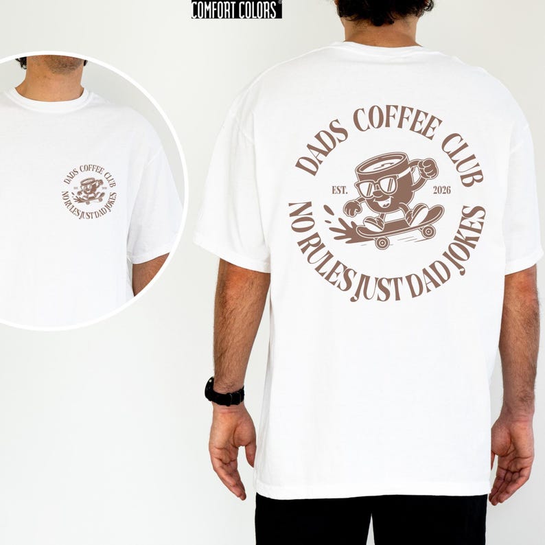 A white t-shirt with a graphic design on the back, featuring a cartoon character riding a skateboard and the text "Dads Coffee Club" around the design.