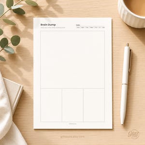 Pode incluir: Um bloco de notas de papel branco com o t&iacute;tulo Brain Dump, uma linha de data com caixas de sele&ccedil;&atilde;o para os dias da semana, um grande espa&ccedil;o retangular em branco e tr&ecirc;s caixas retangulares menores abaixo. O texto GlitzAura est&aacute; impresso na parte inferior.