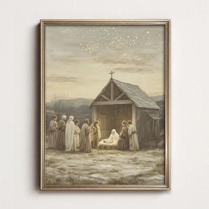 May include: A framed wall art print depicting a nativity scene with a wooden stable topped by a cross. A group of figures in robes stands outside the structure, while a central figure kneels beside a manger under a starry, muted beige sky.