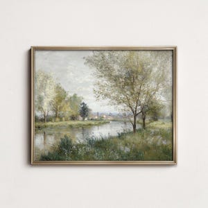 May include: A rectangular landscape painting in a thin gold frame depicting a calm river flowing through a grassy meadow with scattered trees and soft foliage under a cloudy sky. The artwork features muted green, brown, and grey tones.