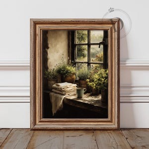 May include: A framed artwork depicts a sunlit interior scene. A wooden window frames a view of lush greenery. Inside, a wooden table holds potted plants, folded linens, and a mug. The artwork is in a rustic, vintage style with warm tones.