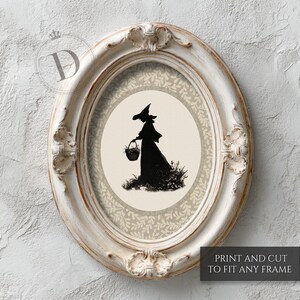 May include: An oval, distressed white frame surrounds a print featuring a black silhouette of a witch carrying a basket. The witch is set against a cream-colored background with a floral patterned border. The text "PRINT AND CUT TO FIT ANY FRAME" is visible.