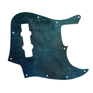 Könnte beinhalten: Ein Bassgitarren-Schlagbrett mit einem dunklen Blau- und Petrol-Farbverlauf und einer gesprenkelten, aquarellartigen Textur. Das Schlagbrett verfügt über einen mittigen Ausschnitt für einen Tonabnehmer und mehrere kleine vorgebohrte Schraublöcher.