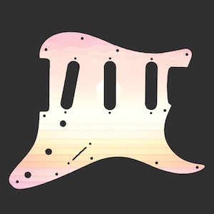 May include: A guitar pickguard with a sunset design. The pickguard is white with a gradient of pink, yellow, and orange hues. It has three elongated holes for the pickups and several smaller holes for screws. The design evokes a serene, natural theme.
