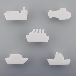 May include: Five white, stylised transport shapes: a ship, a helicopter, a cruise ship, a boat, and a tugboat. The shapes are arranged against a grey background, creating a simple, clean design.