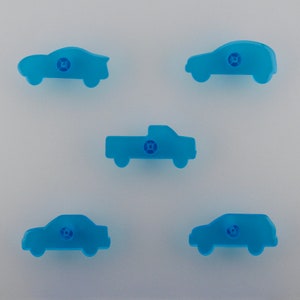 Peut inclure: Cinq véhicules jouets en plastique bleu, dont une voiture, un camion et une camionnette, sur un fond blanc.