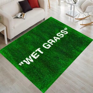Puede incluir: Alfombra verde con el texto "WET GRASS" en letras blancas.