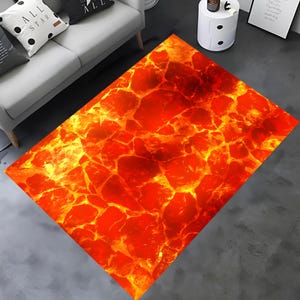 May include: A rectangular rug with a lava-inspired design. The rug displays a vibrant pattern of red, orange, and yellow colours, reminiscent of molten rock. The rug is placed on a grey floor, adding a bold statement to the room.