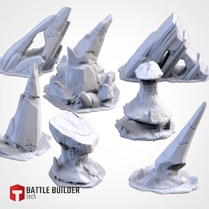 May include: A selection of light grey, stylised rock formations, possibly for tabletop gaming or model building. The set includes various shapes, such as spires, arches, and mushroom-like structures. The "Battle Builder tech" logo is visible in the lower left corner.