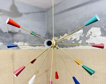 May include: A multi-arm sputnik chandelier featuring a central gold-toned metal sphere with radiating thin rods. Each rod terminates in a conical shade painted in various colors including red, blue, green, yellow, white, and pink.