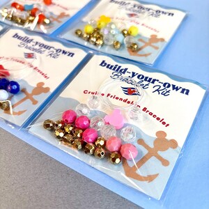 A close-up of a single bracelet kit in its packaging reveals pink beads, gold faceted spacers, and a pink Mickey charm.