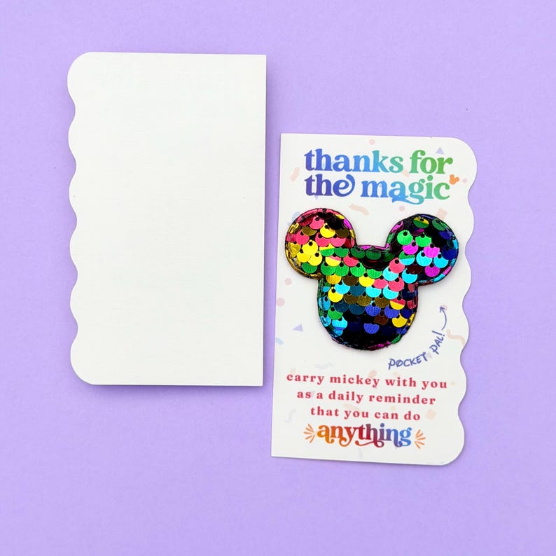 A single white card featuring a rainbow sequin Mickey mouse shape sits next to a blank white card.