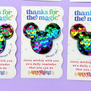 Three white cards with scalloped edges display rainbow sequin Mickey mouse shapes with the text, thanks for the magic.
