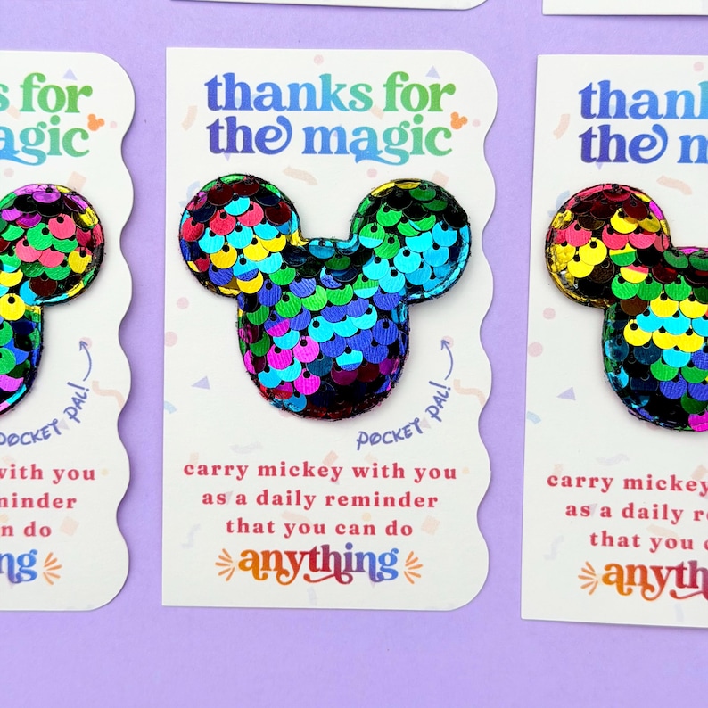 Three white cards with scalloped edges display rainbow sequin Mickey mouse shapes with the text, thanks for the magic.