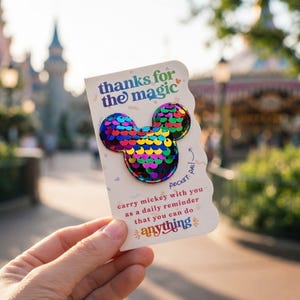 Disney Cast Member Pixie Dust Gifts | DCL Cruise Fish Extender | Rainbow sequin Pocket Pal shown in photo with theme park background