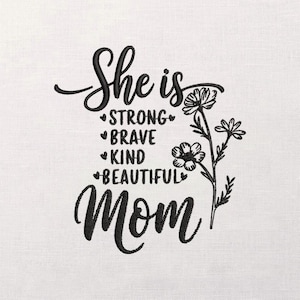 Op de afbeelding: Witte stof met zwart geborduurde tekst en een bloemenontwerp. De tekst luidt "She is STRONG BRAVE KIND BEAUTIFUL Mom". Het bloemenontwerp bevat verschillende bloemen en bladeren.