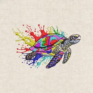 Puede incluir: Diseño bordado de tortuga marina con caparazón colorido y efecto salpicadura. La tortuga presenta un caparazón vibrante con tonos de morado, azul, verde y rojo. El diseño está sobre una tela beige claro.