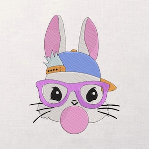 May include: Embroidered design of a cartoon bunny wearing a blue baseball cap, purple glasses, and blowing a pink bubble. The bunny has pink ears and a small pineapple on the cap. Black whiskers are visible.