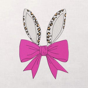 Puede incluir: Orejas de conejo bordadas con un lazo rosa brillante. Las orejas son blancas con un estampado de leopardo en el interior. El lazo es de color fucsia vibrante. Ideal para manualidades temáticas de Pascua o primavera.