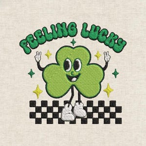 Può includere: Design ricamato con un trifoglio verde sorridente con braccia e gambe, che indossa scarpe bianche e fa il segno della pace. Il testo "FEELING LUCKY" è arcuato sopra il trifoglio. Stelle gialle e un bordo a scacchi bianchi e neri completano il design.